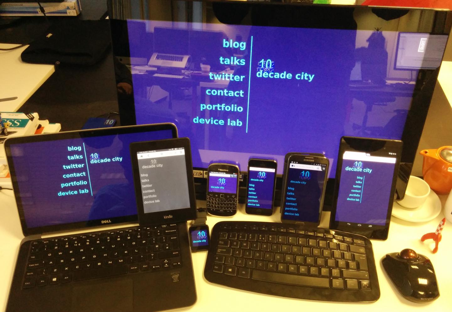 A variety of mobile devices, plus a laptop and a big desktop monitor, all displaying the same website and all having touch capability.